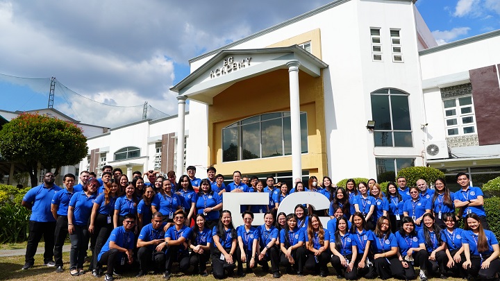EG Academyの近代的な校舎の前に笑顔で大集合した多国籍な講師陣と日本人留学生、正規日本窓口をサポートするスタッフ一同