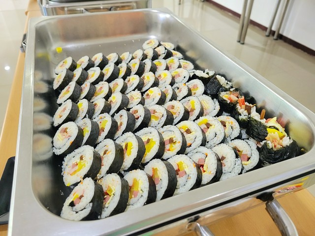 EG Academyの食堂で留学生向けにバランスよく綺麗に並べられて提供される日本ののり巻きと蕎麦のビュッフェメニュー