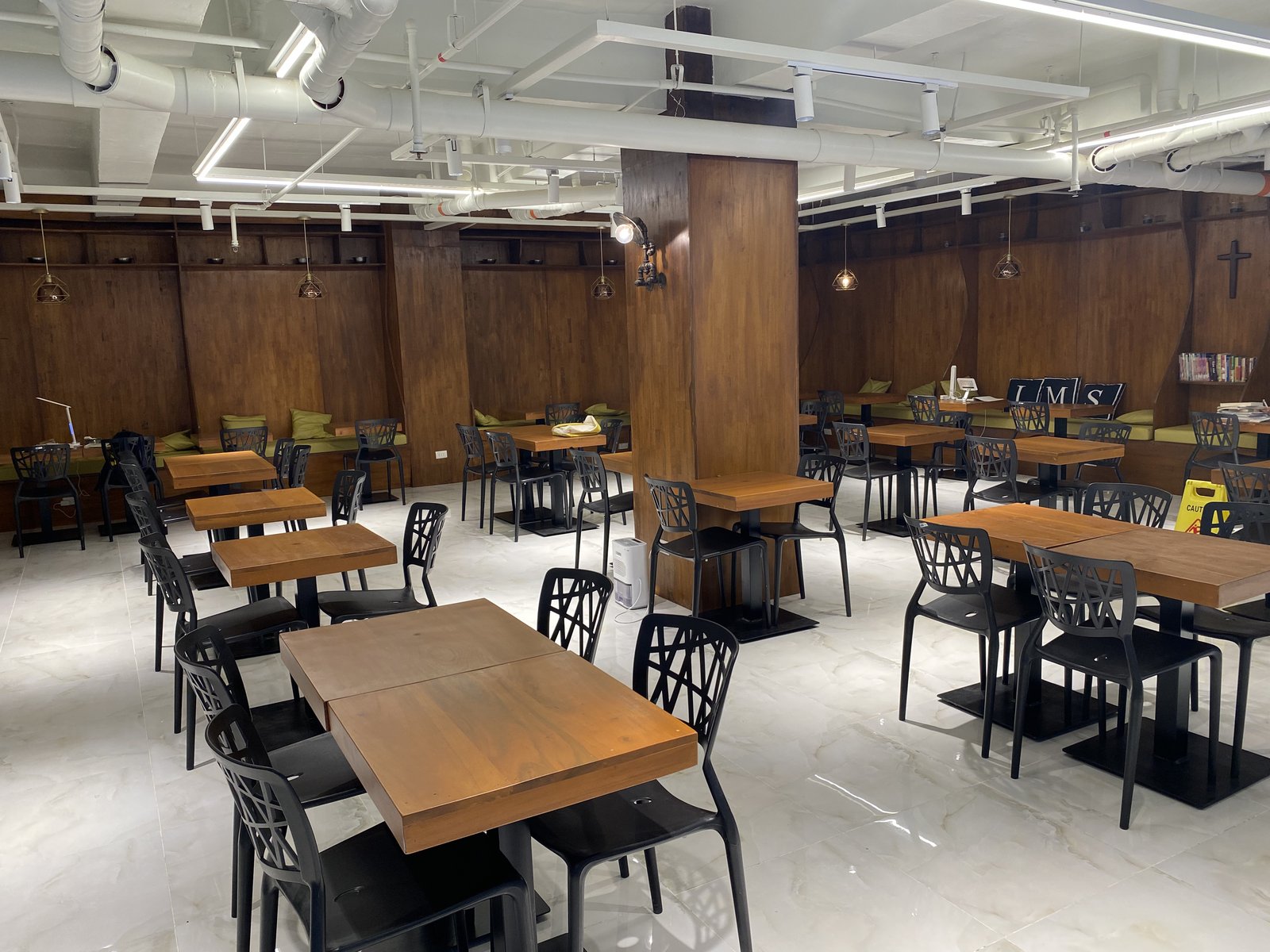IMS Academyの食堂兼ラウンジ。木製テーブルと椅子、壁際のベンチ席