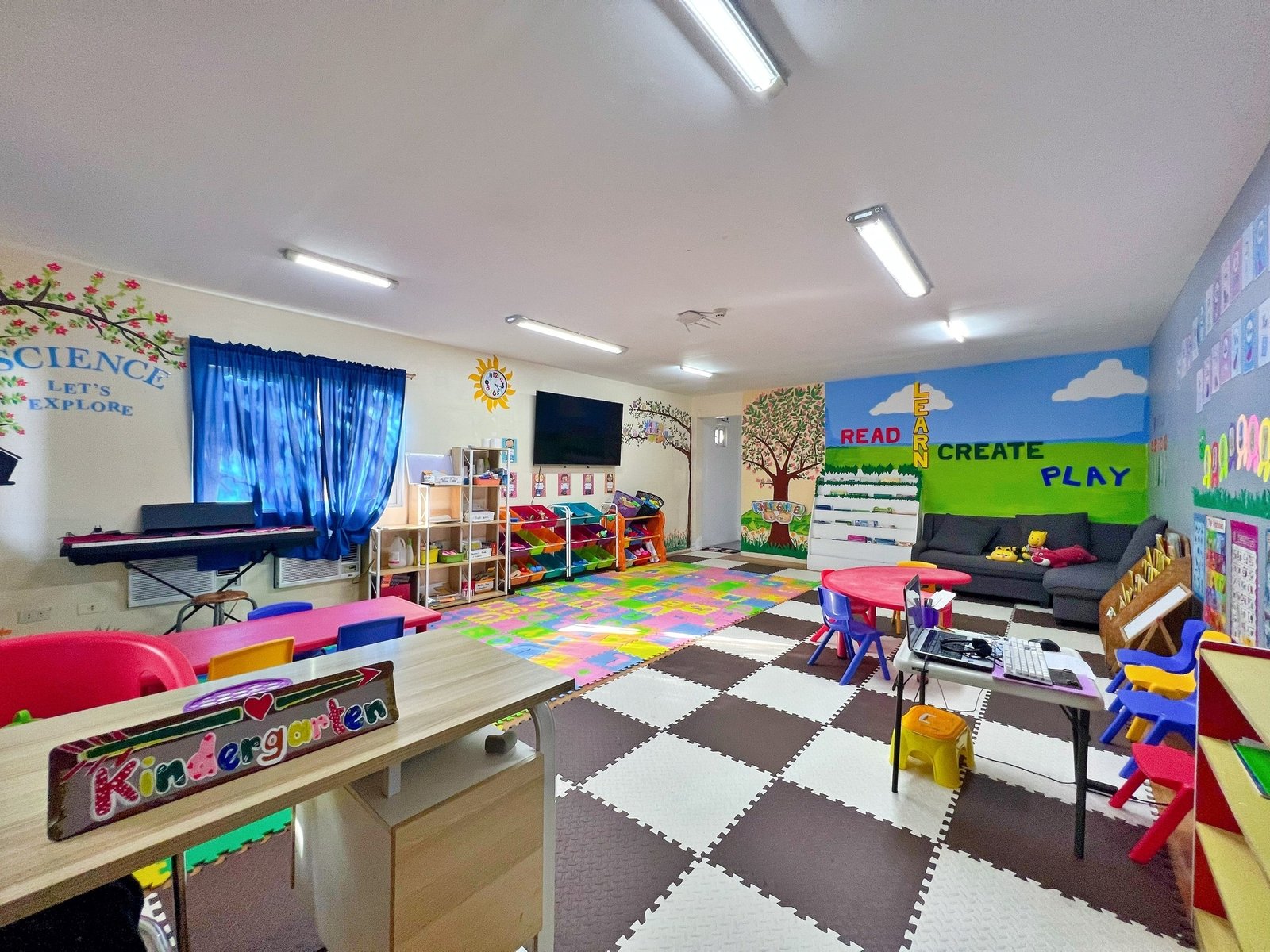 CLARK WE ACADEMY の幼稚園(WE KINDERGARTEN)の教室。ピアノとマットと絵本棚がある