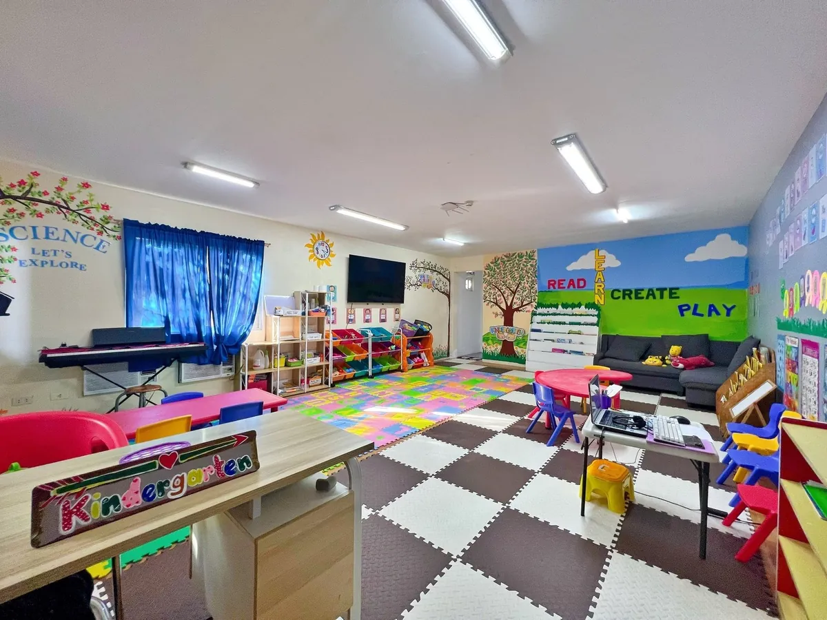 CLARK WE ACADEMY の幼稚園（WE KINDERGARTEN）の教室。ピアノとマットと絵本棚がある
